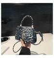 Detail view of leopard print texture and gold metal buckle on trendy crossbody bag - Black