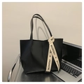 Close-up of black leather tote bag featuring a beige fashion ribbon and large capacity - Black