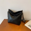 Borsa hobo nera in pelle con tracolla larga a motivi colorati vintage su tavolo di legno - Nero