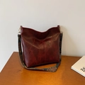 Borsa tote retrò rosso scuro con tracolla larga bohémien su un tavolo di legno - Rosso