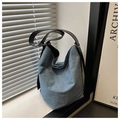 Grande borsa a secchiello in denim blu con ampia tracolla in pelle nera e fibbia metallica - Azzurro