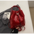 Detailed macro of red patent leather bucket bag with silver butterfly metal buckle - Red