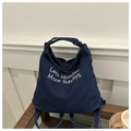 Detail der blauen Denim-Einkaufstasche mit weißer Less Mondays More Sundays Stickerei - Dunkelblau