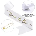 Dettaglio della fascia Bride to Be in raso bianco con scritta dorata e bordi smerlati - Bianco (Testo Oro-Spilla Standard)