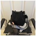 Modische schwarze Eimertasche mit Strassbesatz und gewebtem Schultergurt auf Buch - Schwarz