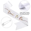 Close-up of Bride to Be white satin sash with gold foil lettering and rhinestone pin - White (Rose Gold Text-Rhinestone Pin)