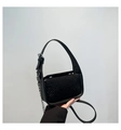 Macro detail of black handbag featuring dense rhinestone embellishments and silver chain strap - Black