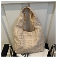Grand sac fourre-tout beige avec jacquard à franges carrées texturées sur une chaise - Carreaux Kaki
