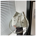 Detail der gerafften Leder-Beuteltasche mit silbernen Schmetterlingen und Kettenzug - Grün