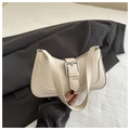Detail of cream faux leather baguette bag featuring a silver metal buckle and short strap - White