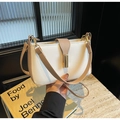 Dettaglio della borsa a tracolla bianco perla con fibbia dorata e cinturino beige - Cachi