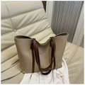 Macro-opname van de minimalistische beige leren shopper met bruine riemen op een bank - Khaki