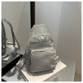 Detalle de la mochila gris plateada con tres bolsillos con cremallera y textura arrugada - Plateado