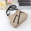 Borsa a tracolla in nylon beige con cerniere nere su una scrivania da ufficio moderna - Cachi