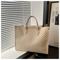 Dettaglio borsa tote beige con stampa M e manici robusti su una superficie scura - Motivo M Bianco Crema