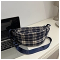 Détail du sac banane à carreaux vintage avec bandoulière réglable sur bureau blanc - Bleu