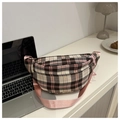 Détail d'un sac banane à carreaux roses posé sur un bureau à côté d'un ordinateur - Rose
