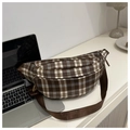 Détail d'un sac banane vintage à carreaux avec sangle marron sur un bureau blanc épuré - Marron