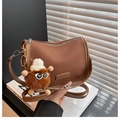 Braune matte Halbmond-Umhängetasche mit Plüsch-Monster-Anhänger und Fashion-Patch - Braun mit Anhänger