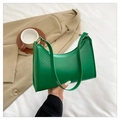 Detail van een levendige groene hobo tas met leertextuur en goudkleurige details op wit bed - Groen