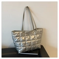 Close-up of metallic silver quilted tote bag with reinforced metal rivets on straps - Silver