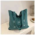 Detail of dark teal corduroy tote bag featuring white letter embroidery and wide straps - Light Green