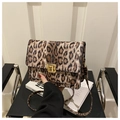 Close-up of leopard print crossbody bag featuring a gold square metal lock and flap - Coffee