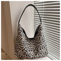 Makro-Detail der großen Hobo-Tasche mit schwarz-weißem Leopardenmuster und Lederriemen - Weiß