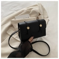 Borsa a tracolla nera minimalista con fibbia dorata su un blazer bianco crema - Nero