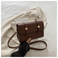 Borsa a tracolla vintage marrone scuro con dettagli dorati su un blazer beige elegante - caffè