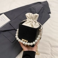 Mini black bucket bag with large pearl handle and gold chain strap in a stylish setup - Black