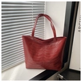 Detail of burgundy leather tote bag featuring unique 3D embossed rib cage bone texture - Red