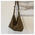 Close-up of leopard print hobo bag with unique knotted strap detail on white wall - Brown