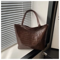 Detailed view of dark brown tote bag featuring unique ribcage embossed skeleton design - Coffee