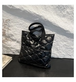 Detail of black quilted puffer bag showing glossy nylon texture and padded handles - Black