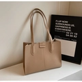 Close-up of minimalist beige tote bag showing matte leather texture and FASHION embossed label - Khaki