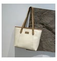 Detalle del bolso tote bicolor en cuero PU crema con ribete marrón y etiqueta de moda - Blanco