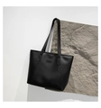 Vista detallada del bolso tote negro minimalista con logo FASHION en cuero fino - Negro