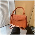 Detalle de bolso de cuero tejido a mano color caramelo con solapa y asa con nudo - Marrón