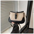 Detail der Schultertasche aus beige Segeltuch und schwarzem Leder mit goldener Schnalle - Schwarz