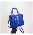 Detalle de bolso acolchado azul real con colgante SSS dorado y borlas decorativas - Azul