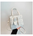 Detalle de un bolso acolchado blanco con textura de triángulo y colgante dorado S - Blanco