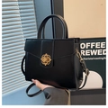 Bolso negro estructurado con elegante cierre de flor dorada y correa ajustable - Negro