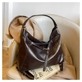 Detail of vintage brown leather tote bag with glossy finish and gold metal buckle hardware - Coffee