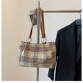 Dettaglio della borsa tote in lana scozzese con tracolla in pelle marrone e anelli in metallo - Quadri Cachi