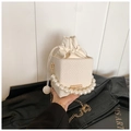 Weiße geflochtene Box-Tasche mit Perlengriff und goldener Kette in der Hand gehalten - Weiß