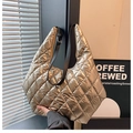 Detail der metallisch-goldenen Stepptasche mit verstellbarem schwarzem Trageriemen - Gold
