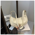 Dettaglio della borsa a mezzaluna crema con pelle martellata e fibbia in metallo dorato - Bianco
