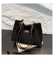 Vista dettagliata della borsa tote in velluto nero con catena d'oro e texture a righe - Nero