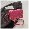 Detail of pink quilted handbag with gold chain on grey blazer and book - Rose Pink